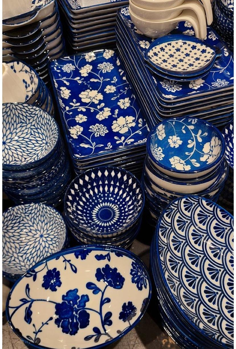 collection of blue and white ceramic dinnerware, including bowls, plates, and trays